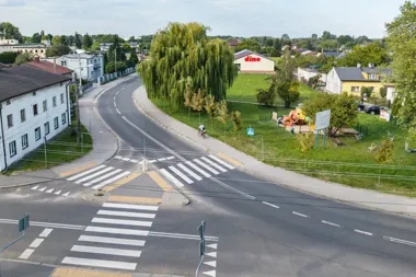 Widok z góry na skrzyżowanie z przejściami dla pieszych, plac zabaw i sklep Dino w małym mieście.
